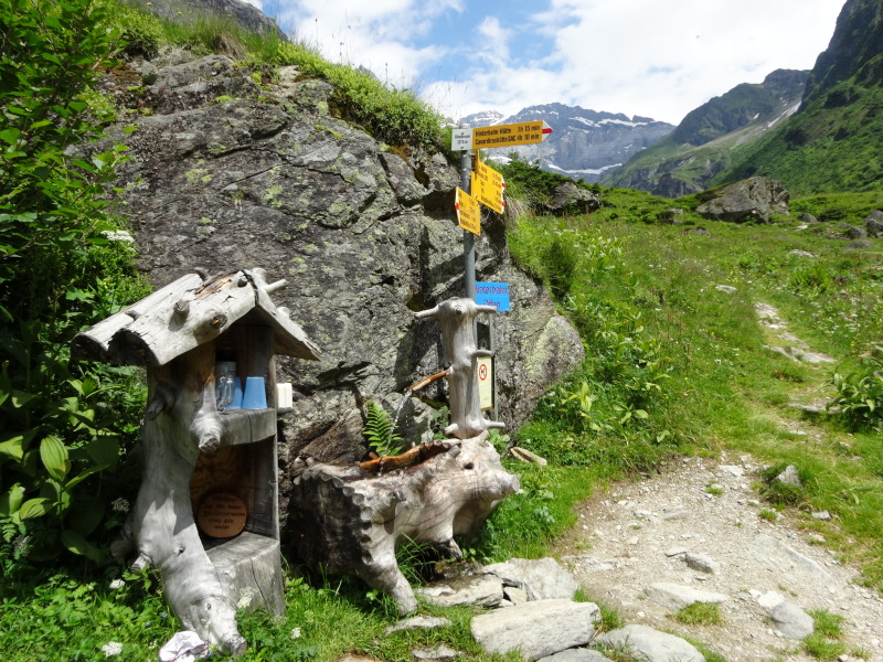 Wegweiser und Holzbrunnen beim Blindensee im Maderanertal